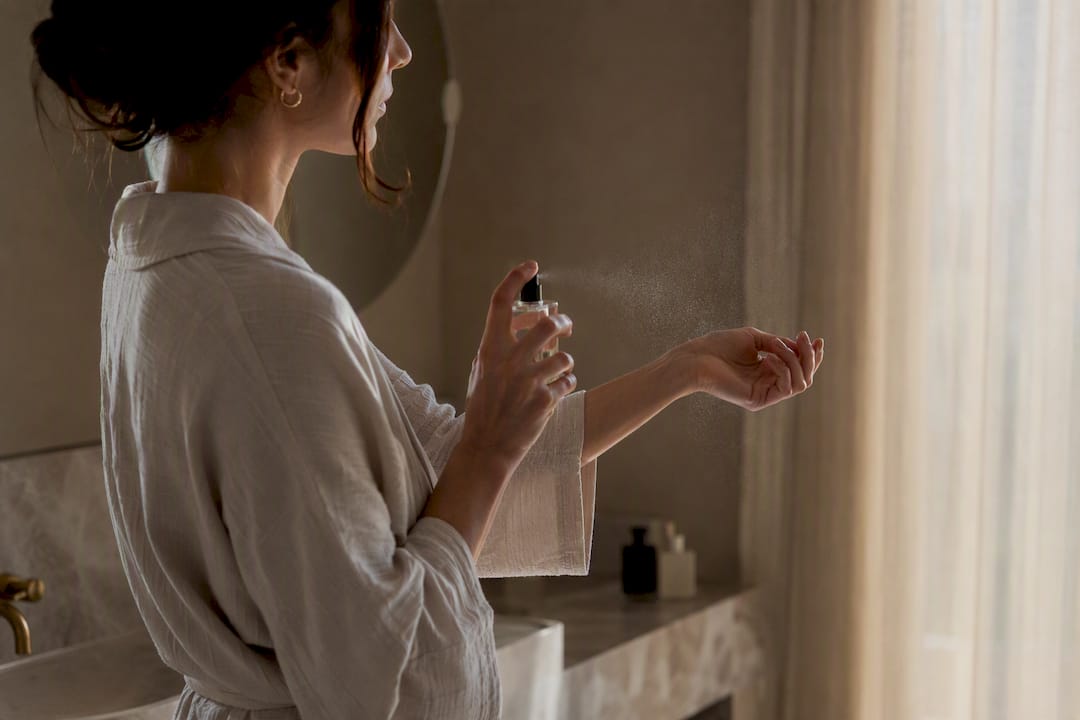 Vrouw die zoete parfum op haar pols spuit